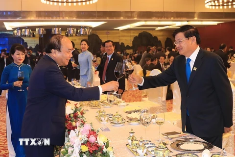 Thủ tướng Nguyễn Xuân Phúc nâng ly chúc mừng Thủ tướng Lào Thongloun Sisoulith. (Ảnh: TTXVN)