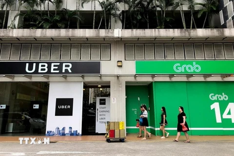 Văn phòng Grab (phải) và Uber (trái) tại Singapore ngày 26/3. (Nguồn: AFP/TTXVN)