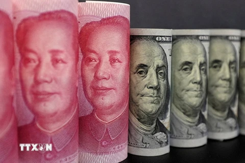 Đồng tiền giấy 100 nhân dân tệ (trái) và đồng USD ở Bắc Kinh. (Nguồn: Reuters/TTXVN)