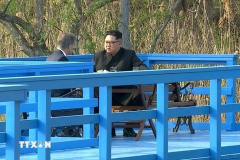 Tổng thống Hàn Quốc Moon Jae-in (trái) và nhà lãnh đạo Triều Tiên Kim Jong-un trong cuộc thảo luận trên một cây cầu gỗ tại làng đình chiến Panmunjom ngày 27/4. (Nguồn: Yonhap/TTXVN)