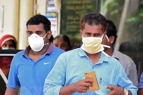Người dân Ấn Độ đeo khẩu trang để phòng tránh nhiễm virus Nipah tại Kozhikode ngày 21/5. (Nguồn: AFP/TTXVN)