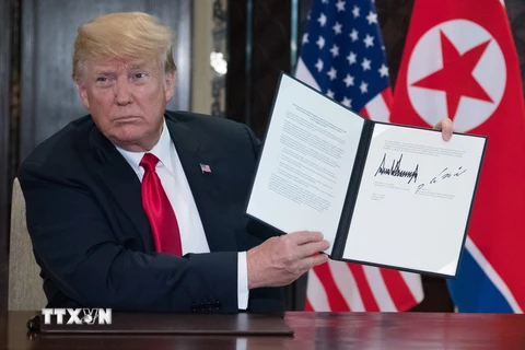 Tổng thống Mỹ Donald Trump công bố văn kiện vừa được ký kết với Nhà lãnh đạo Triều Tiên Kim Jong-un tại Sentosa, Singapore ngày 12/6. (Nguồn: AFP/TTXVN)