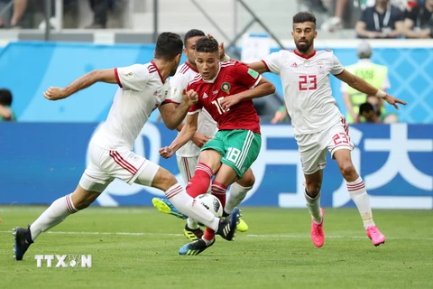 Các cầu thủ Iran (áo trắng) tranh bóng với các cầu thủ Maroc trong trận đấu trong khuôn khổ bảng B World Cup 2018 ở Saint Petersburg, Nga ngày 15/6. (Nguồn: THX/TTXVN)