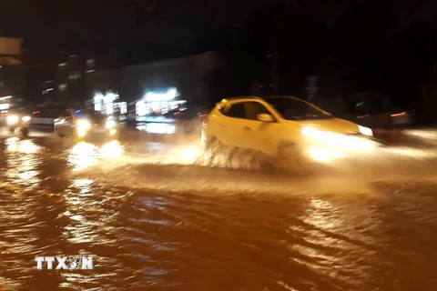 Các phương tiện di chuyển trên mặt đường Phạm Văn Đồng, quận Cầu Giấy bị ngập nước tối 15/7. (Ảnh: Văn Điệp/TTXVN)