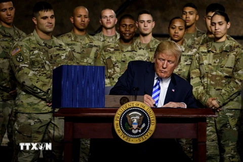 Tổng thống Mỹ Donald Trump (phía trước) ký ban hành Đạo luật Chi tiêu Quốc phòng (NDAA) tài khóa 2019 tại căn cứ Fort Drum ở New York ngày 13/8. (Nguồn: AFP/TTXVN)