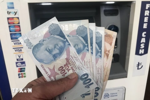 Kiểm đồng lira tại một máy rút tiền tự động ở Istanbul, ngày 14/8. (Nguồn: THX/TTXVN)