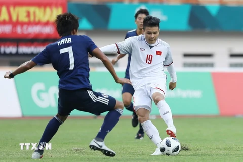 Tiền vệ Quang Hải (19) trong một pha tranh bóng với cầu thủ đội tuyển Olympic Nhật Bản. (Ảnh: Hoàng Linh/TTXVN)