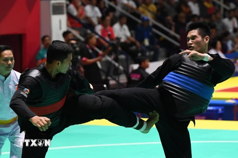 Vận động viên Nguyễn Duy Tuyến (phải) tranh tài với vận động viên Aji Bangkit Pamungka (trái) của Indonesia ở nội dung Pencak Silat hạng cân 85-90kg dành cho nam tại ASIAD 2018 diễn ra ở Jakarta, Indonesia ngày 26/8. (Nguồn: AFP/TTXVN)