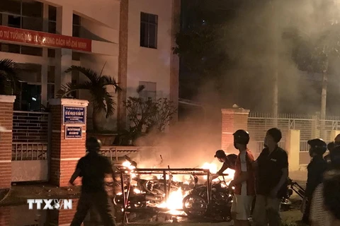 Một số đối tượng quá khích ở tỉnh Bình Thuận lôi xe máy từ trong Sở Kế hoạch và Đầu tư ra đốt phá. (Ảnh: Nguyễn Thanh/TTXVN)