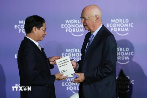 Giáo sư Klaus Schwab, Người sáng lập, Chủ tịch Điều hành Diễn đàn Kinh tế thế giới (bên phải) trao sách tặng Thứ trưởng Thường trực Bộ Ngoại giao Bùi Thanh Sơn. (Ảnh: Lâm Khánh/TTXVN) 