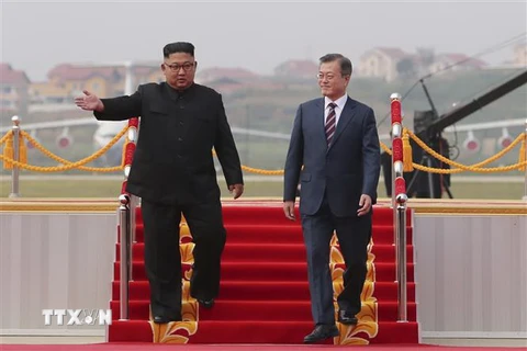Nhà lãnh đạo Triều Tiên Kim Jong-un (trái) đón Tổng thống Hàn Quốc Moon Jae-in (phải) ở sân bay quốc tế Bình Nhưỡng ngày 18/9. (Nguồn: YONHAP/TTXVN)
