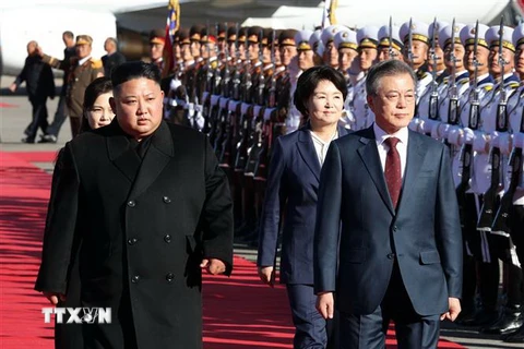 Tổng thống Hàn Quốc Moon Jae-in (phải) và nhà lãnh đạo Triều Tiên Kim Jong-un (trái) duyệt đội danh dự tại sân bay Samjiyon trước khi thăm núi Paekdu ở tỉnh Ryanggang (Triều Tiên) ngày 20/9. (Nguồn: Yonhap/TTXVN)