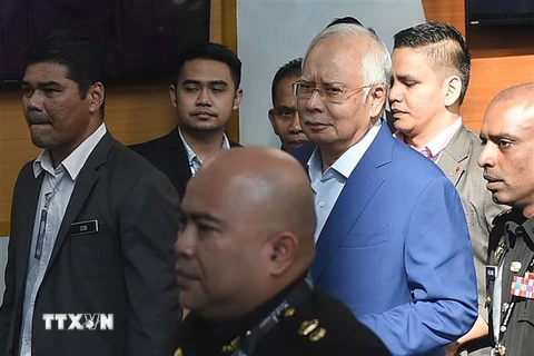 Cảnh sát áp giải cựu Thủ tướng Malaysia Najib Razak (giữa) tới Văn phòng Ủy ban chống tham nhũng ở Putrajaya ngày 22/5. (Nguồn: THX/TTXVN)