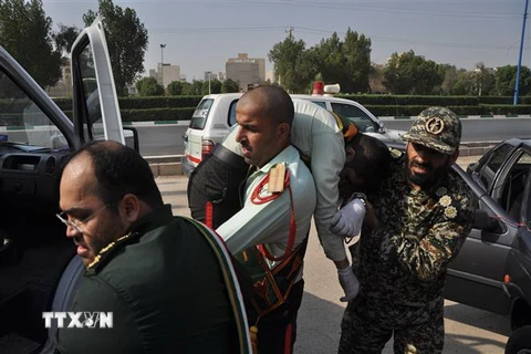 Chuyển một thành viên IRGC bị thương tại hiện trường vụ tấn công nhằm vào lễ diễu binh ở thành phố Ahvaz, Iran ngày 22/9. (Nguồn: AFP/TTXVN)