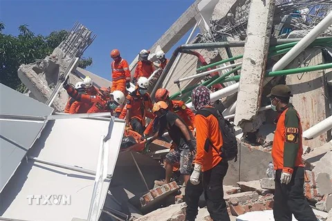 Lực lượng cứu hộ tìm kiếm nạn nhân trong đống đổ nát của một tòa nhà bị sập sau thảm họa động đất, sóng thần tại tỉnh Trung Sulawesi, Indonesia ngày 30/9. (Nguồn: AFP/TTXVN)