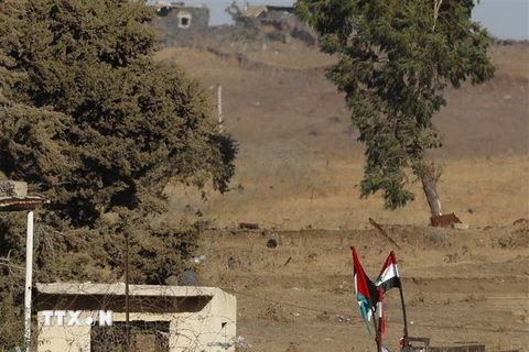 Quốc kỳ Syria được treo gần khu định cư Ein Zivan trên Cao nguyên Golan bị Israel chiếm đóng ngày 26/7. (Nguồn: AFP/TTXVN)
