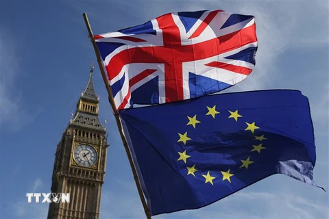 Cờ Liên minh châu Âu (EU) (bên dưới) và Quốc kỳ Anh tại London (Anh). (Nguồn: AFP/TTXVN) 