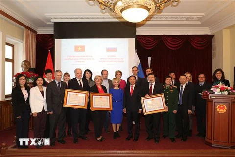 Đại sứ Ngô Đức Mạnh chụp ảnh lưu niệm với đại diện 3 trường được tặng thưởng Huân chương Hữu nghị. (Ảnh: Dương Trí/TTXVN) 