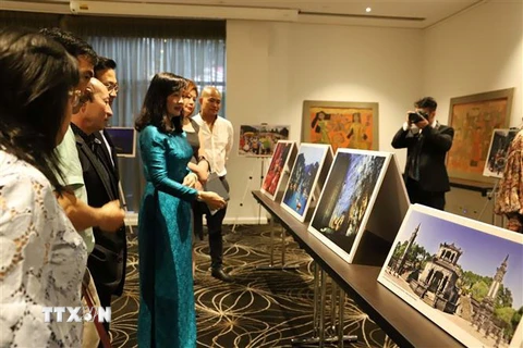 Khách tham quan triển lãm tranh sơn mài và ảnh nghệ thuật Việt Nam. (Ảnh: Diệu Linh/TTXVN) 