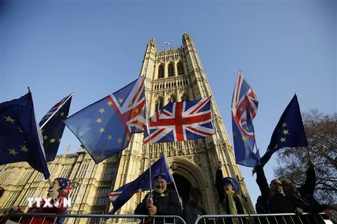 Những người phản đối Brexit mang cờ Anh và cờ Liên minh châu Âu bên ngoài tòa nhà Quốc hội Anh ở London ngày 11/12/2018. (Nguồn: AFP/TTXVN) 