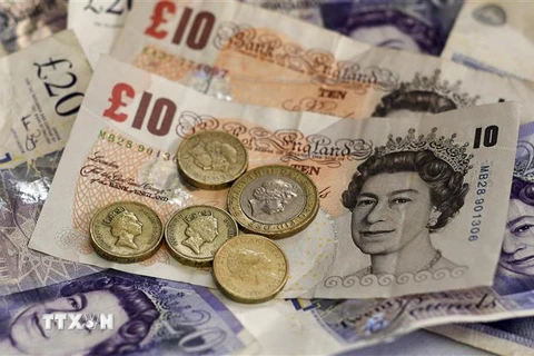 Tiền giấy mệnh giá 10 và 20 bảng Anh cùng tiền xu 1 và 2 bảng Anh tại Liverpool. (Nguồn: AFP/TTXVN) 