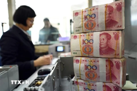Kiểm đồng 100 nhân dân tệ tại ngân hàng ở tỉnh Giang Tô, Trung Quốc. (Nguồn: AFP/TTXVN) 