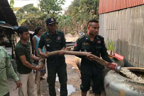 Cảnh sát bơm nước giúp một gia đình ở Koh Kong. (Nguồn: khmertimeskh.com) 