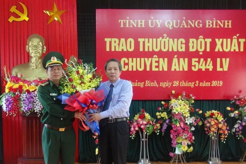 Bí thư Tỉnh ủy Quảng Bình Hoàng Đăng Quang tặng hoa cho Đại diện Bộ chỉ huy Bộ đội biên phòng Quảng Bình sau chuyên án 544LV thành công. (Ảnh: Đức Thọ/TTXVN) 