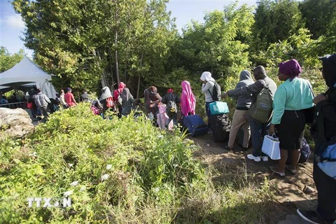 Người tị nạn băng qua biên giới Canada-Mỹ tại Champlain, New York (Mỹ). (Nguồn: AFP/TTXVN) 