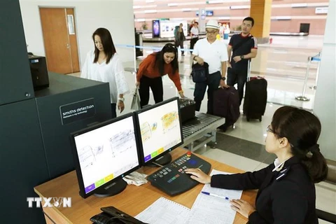 Nhân viên hải quan sử dụng máy soi để kiểm tra hành lý khách nhập cảnh. (Ảnh: Phạm Hậu/ TTXVN) 