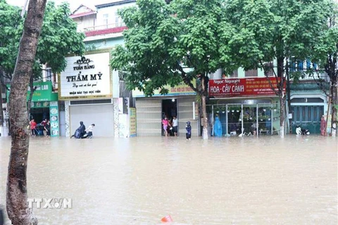 Đường Trường Chinh, thành phố Sơn La bị ngập úng, gây ách tắc giao thông và nước tràn vào nhà dân ven đường. (Ảnh: Nguyễn Cường/TTXVN) 
