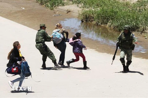 Lực lượng Vệ binh quốc gia Mexico bắt giữ người di cư trong hành trình tới Mỹ đang cố gắng vượt qua Rio Bravo, thuộc Ciudad Juarez, bang Chihuahua (Mexico) ngày 21/6/2019. (Nguồn: AFP/TTXVN) 