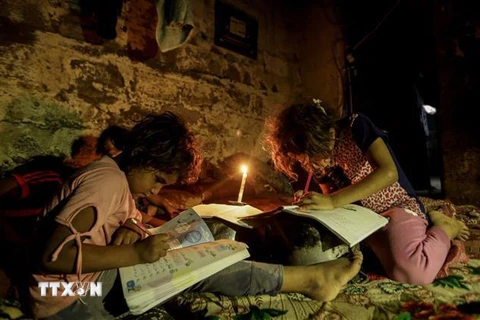 Trẻ em Palestine học bài trong cảnh thiếu điện tại thành phố Gaza. (Nguồn: AFP/TTXVN) 