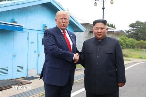 Tổng thống Mỹ Donald Trump (trái) và nhà lãnh đạo Triều Tiên Kim Jong-un trong cuộc gặp tại Khu phi quân sự (DMZ) ngày 30/6/2019. (Nguồn: THX/TTXVN) 