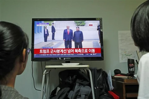 Người dân theo dõi hình ảnh cuộc gặp giữa Tổng thống Mỹ Donald Trump và nhà lãnh đạo Triều Tiên Kim Jong-un được phát sóng trên truyền hình tại Seoul, Hàn Quốc ngày 30/6/2019. (Nguồn: THX/TTXVN) 