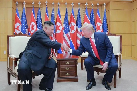 Tổng thống Mỹ Donald Trump (phải) và nhà lãnh đạo Triều Tiên Kim Jong-un trong cuộc gặp thượng đỉnh tại làng đình chiến Panmunjom trong Khu phi quân sự (DMZ) ngày 30/6/2019. (Nguồn: AFP/TTXVN) 