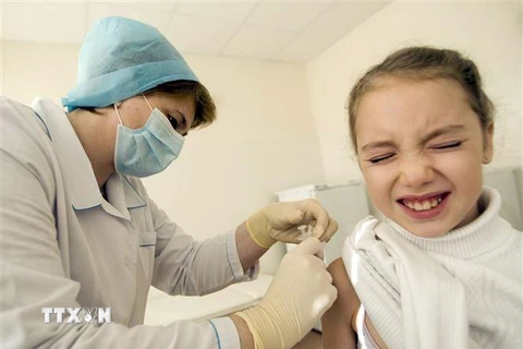 Tiêm vắcxin phòng cúm cho học sinh tại trường học ở Sochi, Nga. (Nguồn: AFP/TTXVN) 
