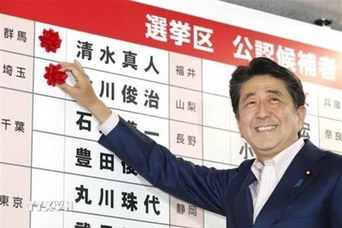 Thủ tướng Nhật Bản, Shinzo Abe gắn những bông hồng nhỏ bên cạnh tên của các ứng cử viên thắng cử của Đảng LDP sau cuộc bầu cử Thượng viện ở Tokyo ngày 21/7. (Nguồn: Kyodo/TTXVN) 