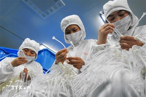 Công nhân làm việc tại một nhà máy sản xuất thiết bị y tế ở tỉnh Giang Tô, Trung Quốc. (Nguồn: AFP/TTXVN) 