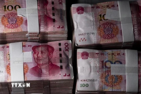 Đồng tiền mệnh giá 100 nhân dân tệ tại Thượng Hải, Trung Quốc. (Nguồn: AFP/TTXVN) 