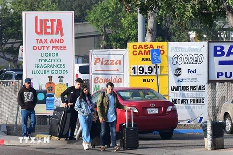 Người di cư di chuyển qua cửa khẩu Otay Mesa ở biên giới Mexico-Mỹ để sang San Diego, bang California (Mỹ) ngày 8/6/2019. (Nguồn: AFP/TTXVN) 