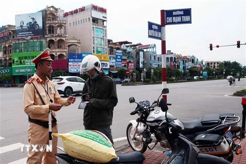 Lực lượng cảnh sát giao thông thành phố Hưng Yên kiểm tra và xử phạt chủ phương tiện vi phạm giao thông. (Ảnh: Phạm Kiên/TTXVN) 