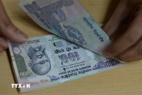 Kiểm tiền mệnh giá 100 rupee của Ấn Độ tại ngân hàng ở Mumbai. (Nguồn: AFP/TTXVN) 