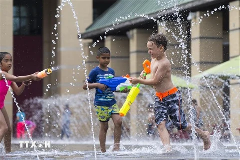 Trẻ em giải nhiệt trong thời tiết nắng nóng tại Ontario, Canada, ngày 5/7. (Nguồn: THX/TTXVN) 