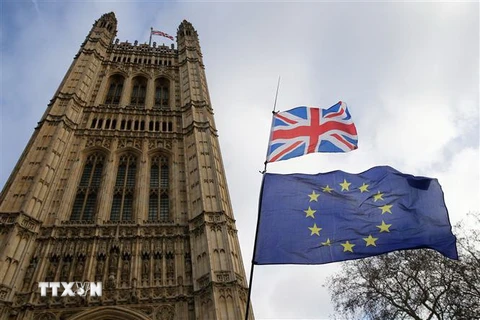 Quốc kỳ Anh (phía trên) và cờ Liên minh châu Âu (phía dưới) bên ngoài tòa nhà Quốc hội Anh ở London. (Nguồn: THX/TTXVN) 