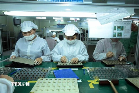 Công nhân sản xuất linh kiện điện tử tại Công ty trách nhiệm hữu hạn 4P ở Hưng Yên. (Ảnh: Phạm Kiên/TTXVN) 