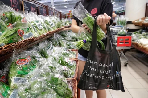 Một người sử dụng túi tái sử dụng miễn phí tại siêu thị ở Singapore. (Nguồn: ST) 