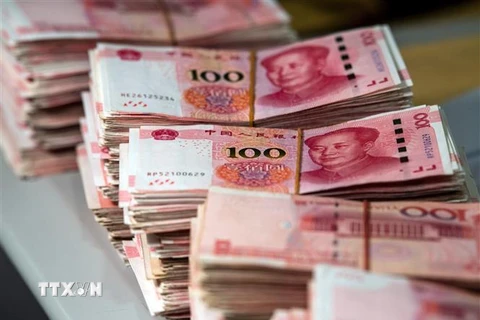 Đồng tiền mệnh giá 100 nhân dân tệ tại Thượng Hải, Trung Quốc. (Nguồn: AFP/TTXVN) 