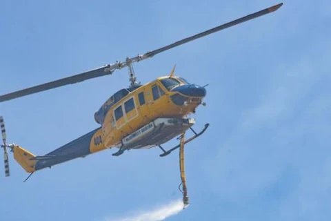 Một máy bay trực thăng ném bom nước xuống đám cháy rừng. (Nguồn: AAP) 