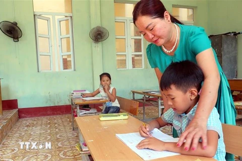 Cô giáo Vũ Thị Hà đang hướng dẫn học sinh lớp 2, Trường tiểu học Bạch Long Vỹ, học bài. (Ảnh: Minh Thu/TTXVN) 